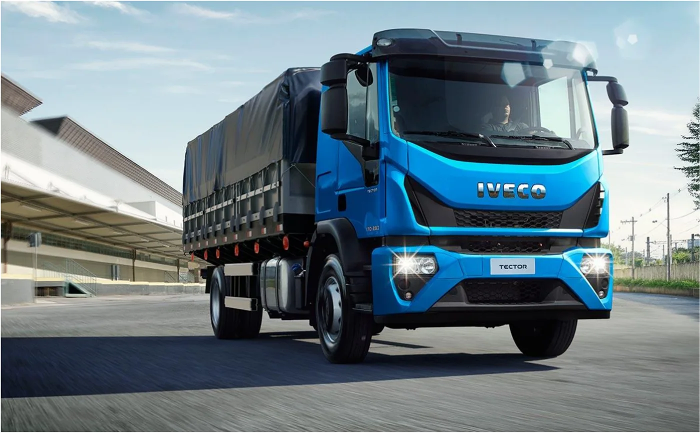 IVECO Tector azul de carga circulando junto a instalaciones industriales