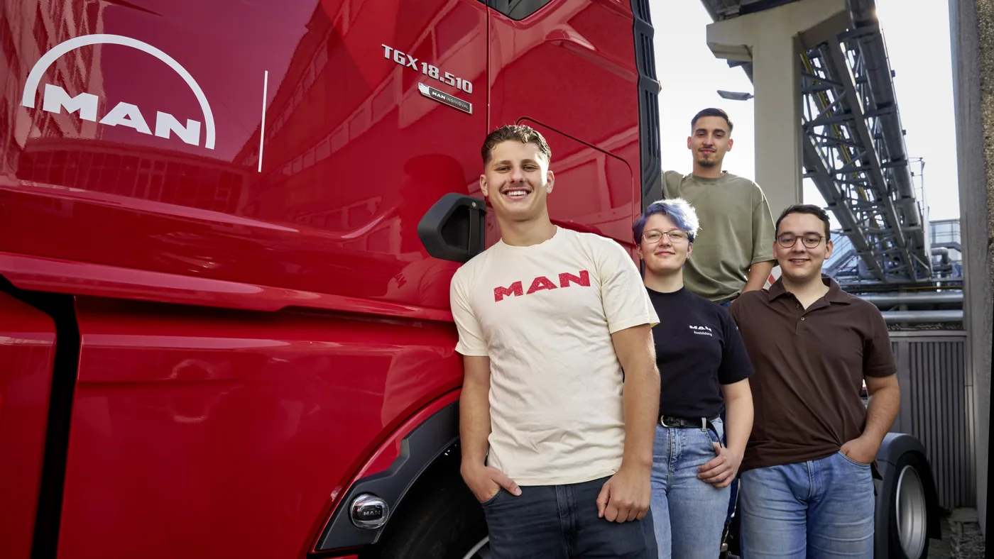 Jóvenes participantes del programa de formación de MAN junto a un camión rojo