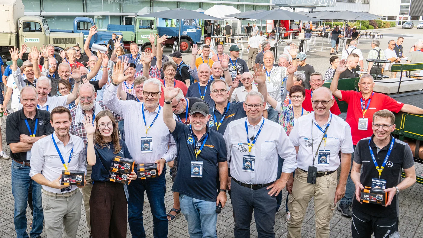 Participantes de la Deutschlandfahrt junto a camiones históricos