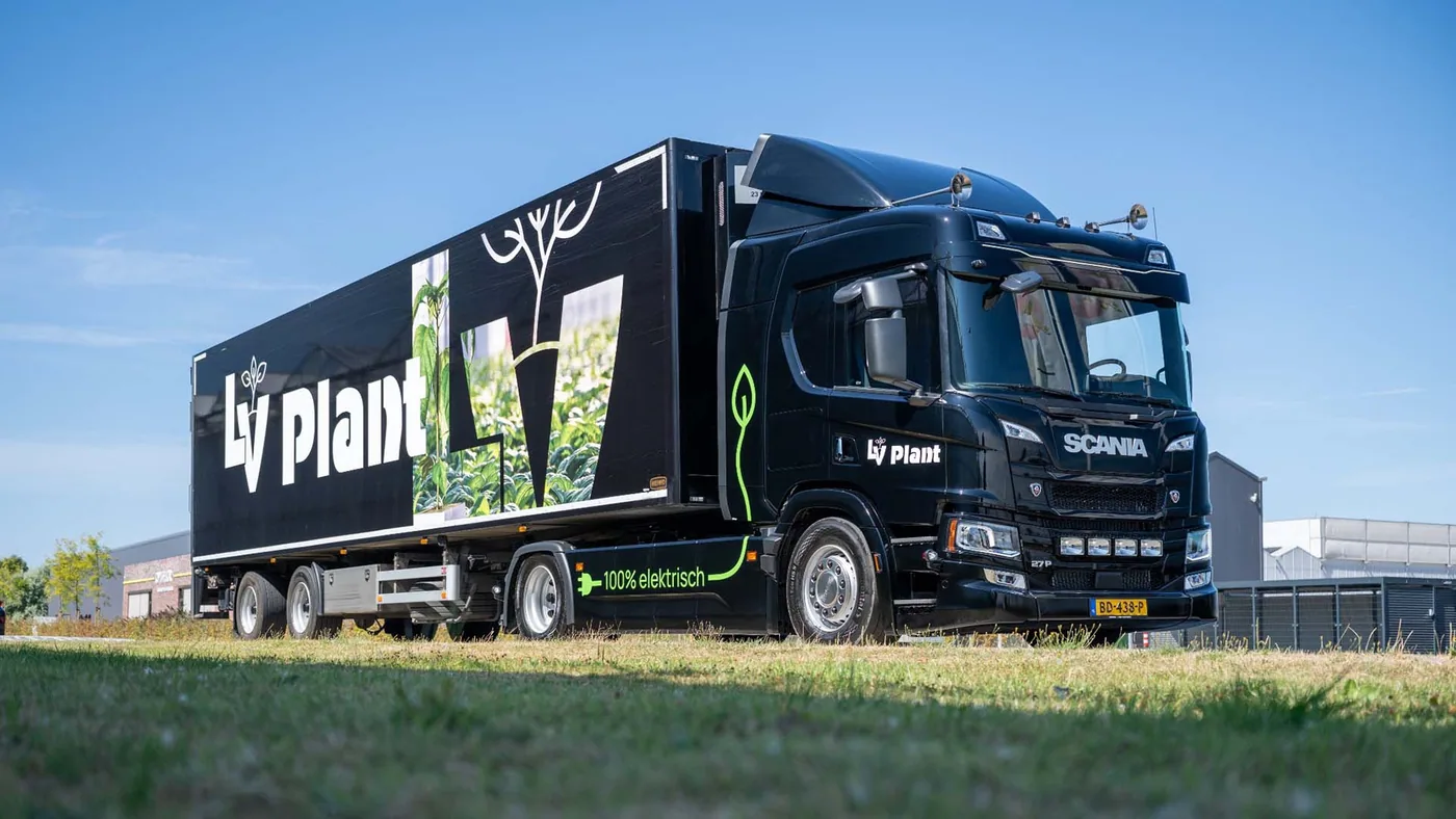 Scania 27P eléctrico estacionado junto a instalaciones hortícolas