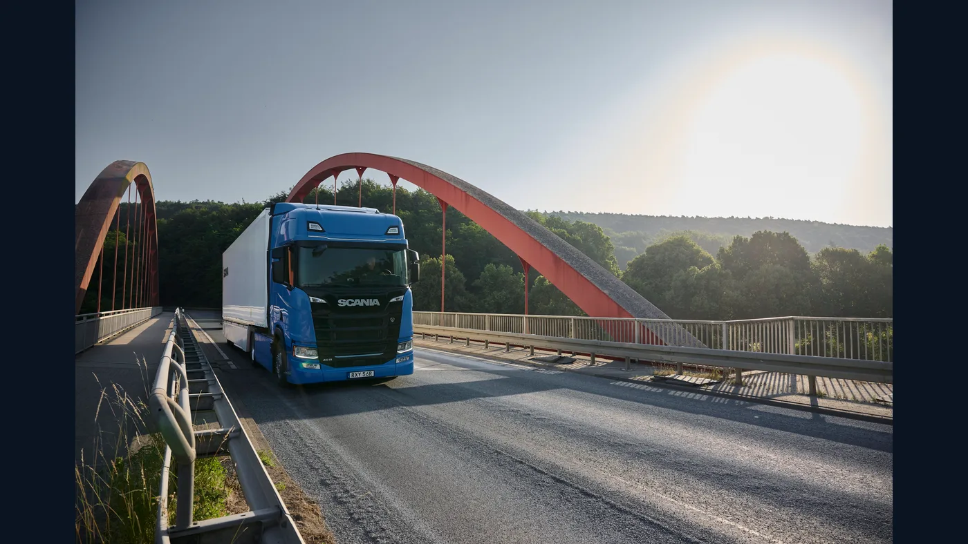 Camión Scania azul circulando por un puente, fotografía oficial del anuncio europeo de seguridad