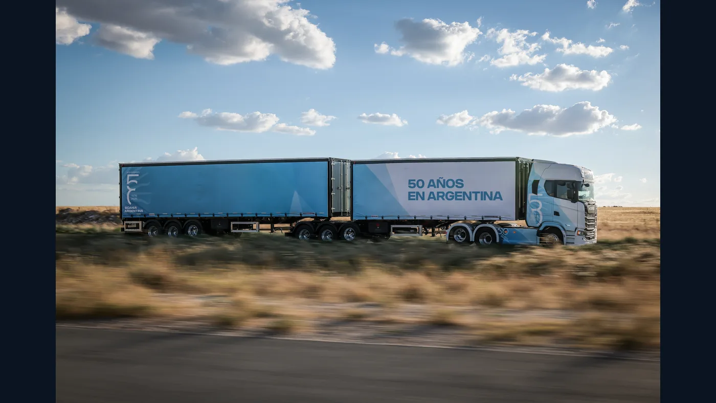 Camión Scania blanco y celeste de la edición 50 años en Argentina con semirremolque sobre una ruta