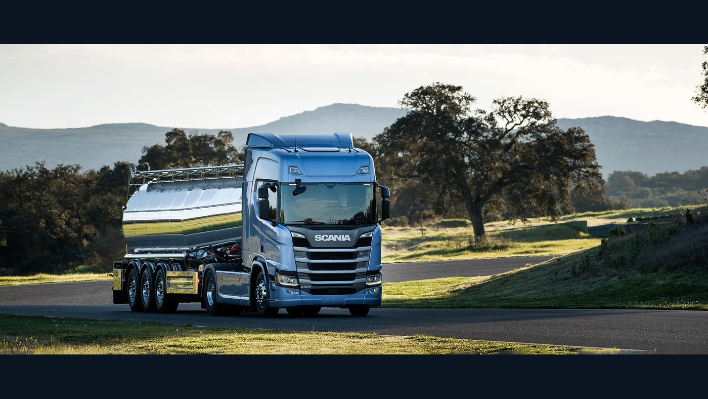 Camión Scania azul de la nueva generación circulando con cisterna por una carretera